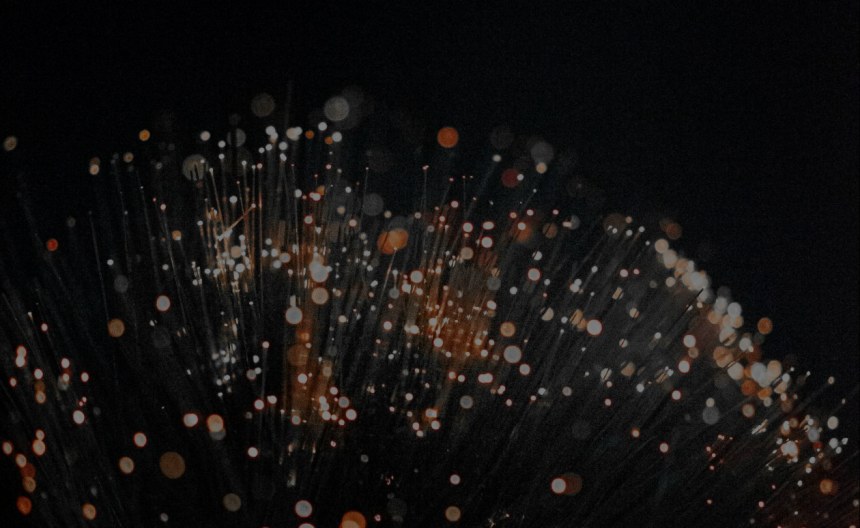 Glowing fiber optic strands representing the software tools powering AV-over-IP installations